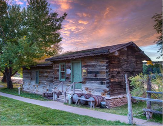 Log cabin against a beautiful pink and purple sunset