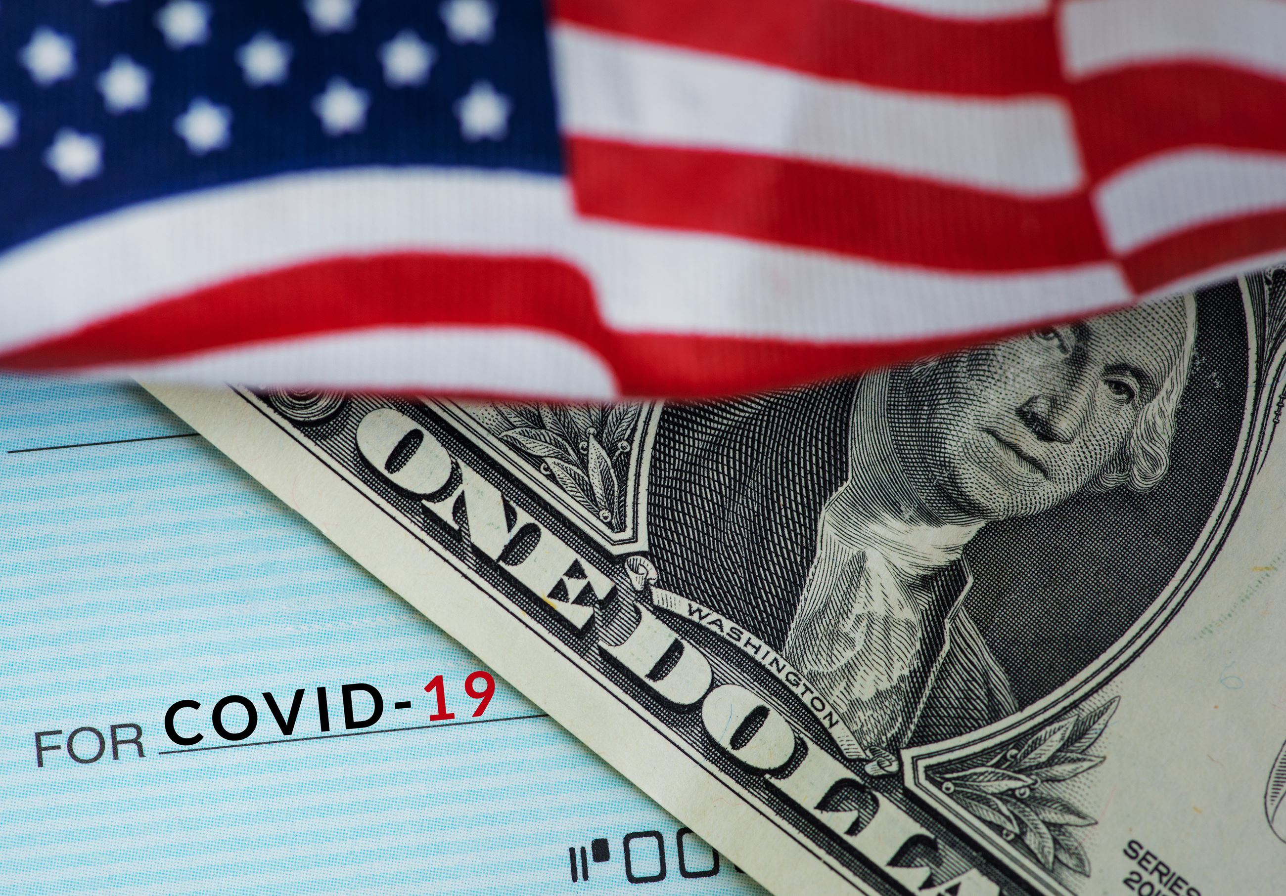 US Flag over Dollar bill and Covid-19 check 