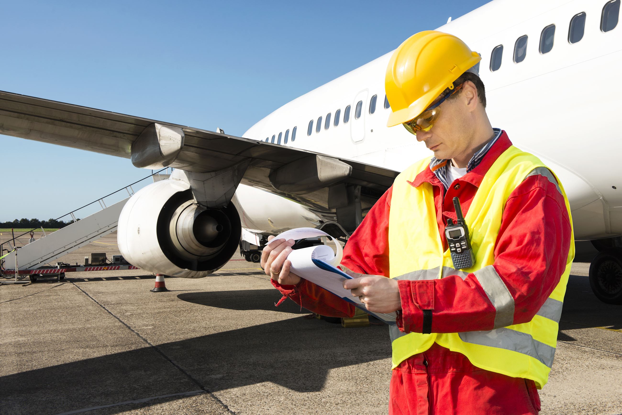 Man with clipboard in front of Airplane