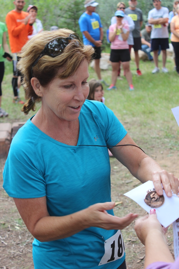 Photo of an age group winner receiving her award for the Tower Rock Run 5k